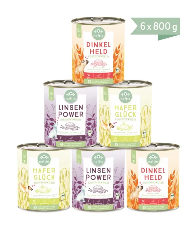 Six 800g tins of Naftie organic vegan wet dog food stacked in a pyramid, in three varieties.
