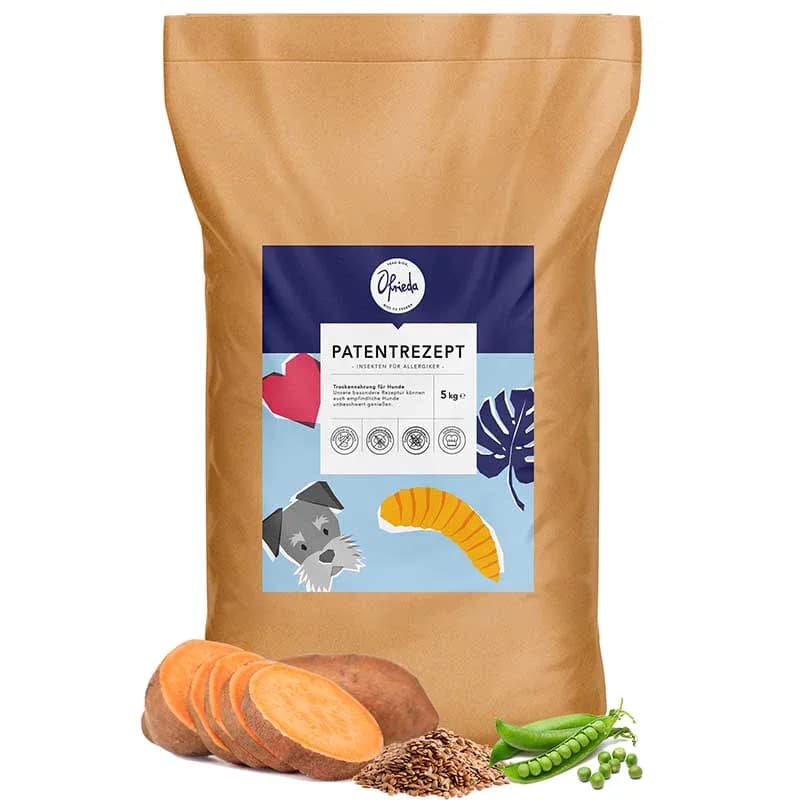 A kraft-paper bag of Ofrieda Patentrezept dry dog food, with sliced sweet potato, flaxseed and peas arranged in front of it.